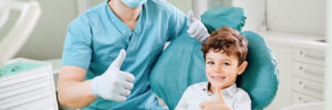 Child and his dentist both give a thumbs up after a great visit