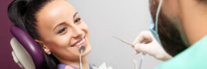 Young woman with beautiful teeth smiling while in dental chair