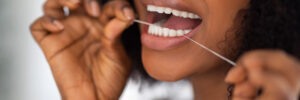 Beautiful woman flossing the bottom of her teeth
